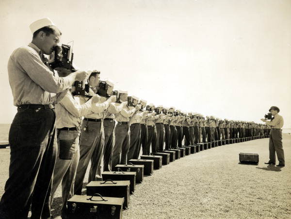 上图是美国海军摄影学校的课程中，同学们正在练习使用相机，摄于1942年 (要带出海吧？)。下图则是两兄弟Richard与Cherry Kearton，他们是生态摄影的先驱，正在示范鸟摄的方法 ！！并且曾于1899年推出著作With Nature and a Camer。